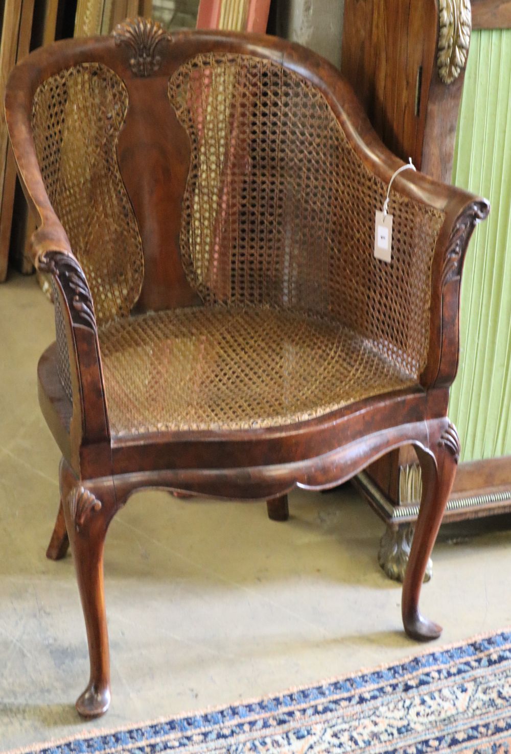 A Queen Anne style caned simulated walnut tub framed elbow chair